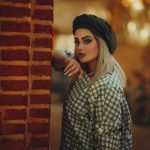 a-woman-leaning-against-a-brick-wall